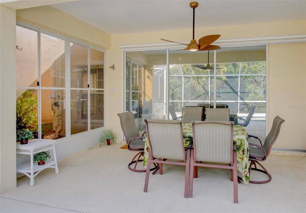 143 Braemar Avenue Venice, FL 34293 - Photo 32 of 36 a dining room with furniture large windows and a chandelier