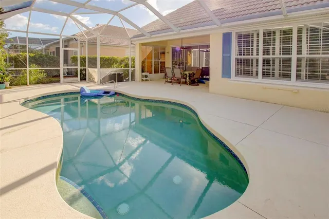 a view of a swimming pool with potted plants and large windows
