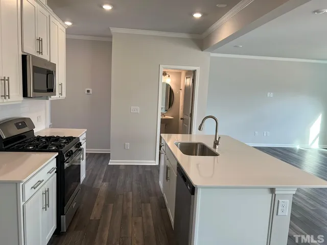 a kitchen with a sink a stove and a microwave