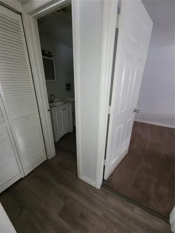 a view of a hallway with wooden floor and entryway