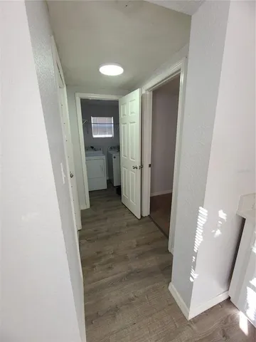 a view of a hallway view with furniture and wooden floor