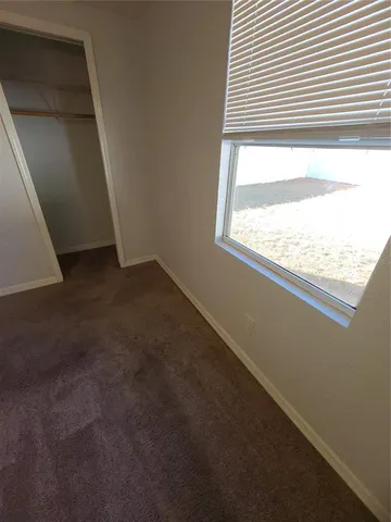 a view of a livingroom with an empty space and a window