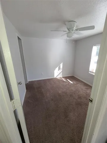 a view of an empty room with a fireplace and a window
