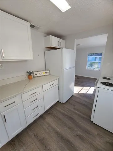 a kitchen with stainless steel appliances a refrigerator sink and wooden floor