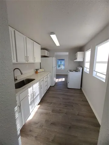 a large white kitchen with cabinets