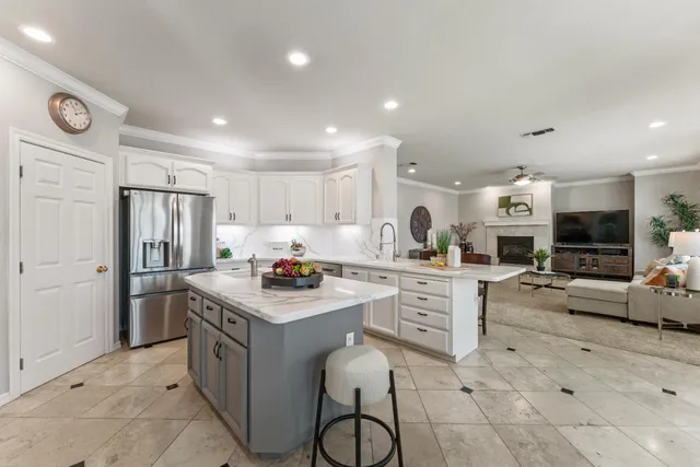 a kitchen that has a lot of white cabinets and stainless steel appliances