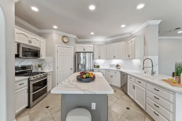a kitchen with white cabinets and appliances