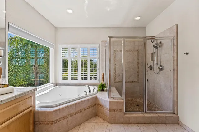 a bathroom with a granite countertop tub shower and sink