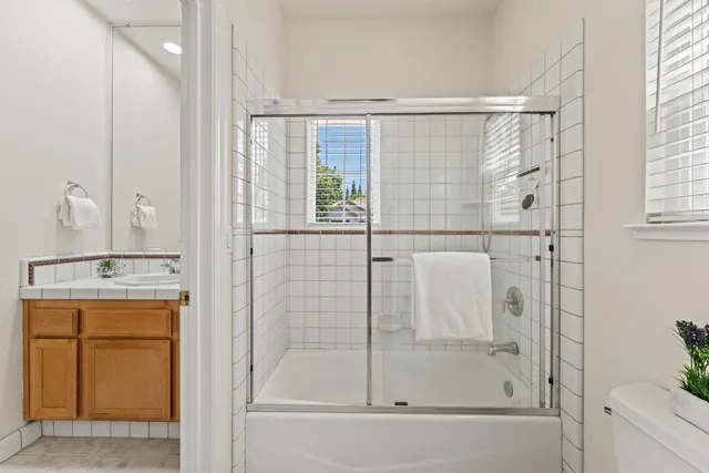 a bathroom with a shower a mirror and a sink