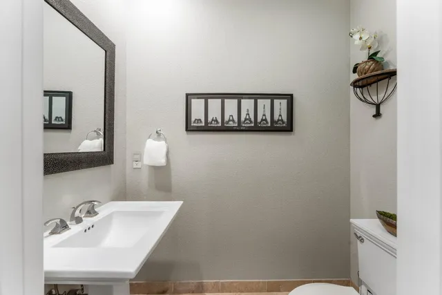 a bathroom with a toilet sink and mirror