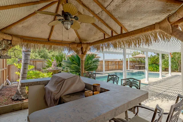 a view of a patio with table and chairs under an umbrella