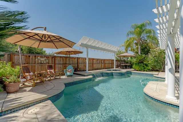 a view of a backyard with table and chairs under an umbrella