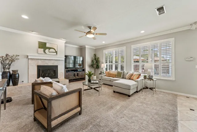 a living room with furniture fireplace and a large window
