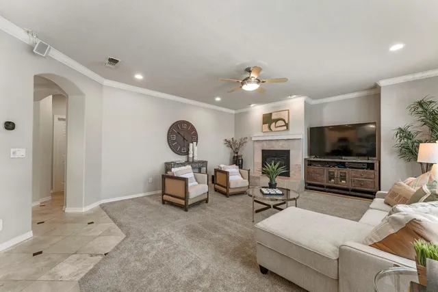 a living room with furniture a flat screen tv and a fireplace