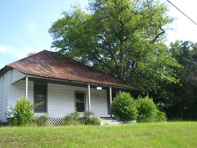 a front view of a house with a yard and trees
