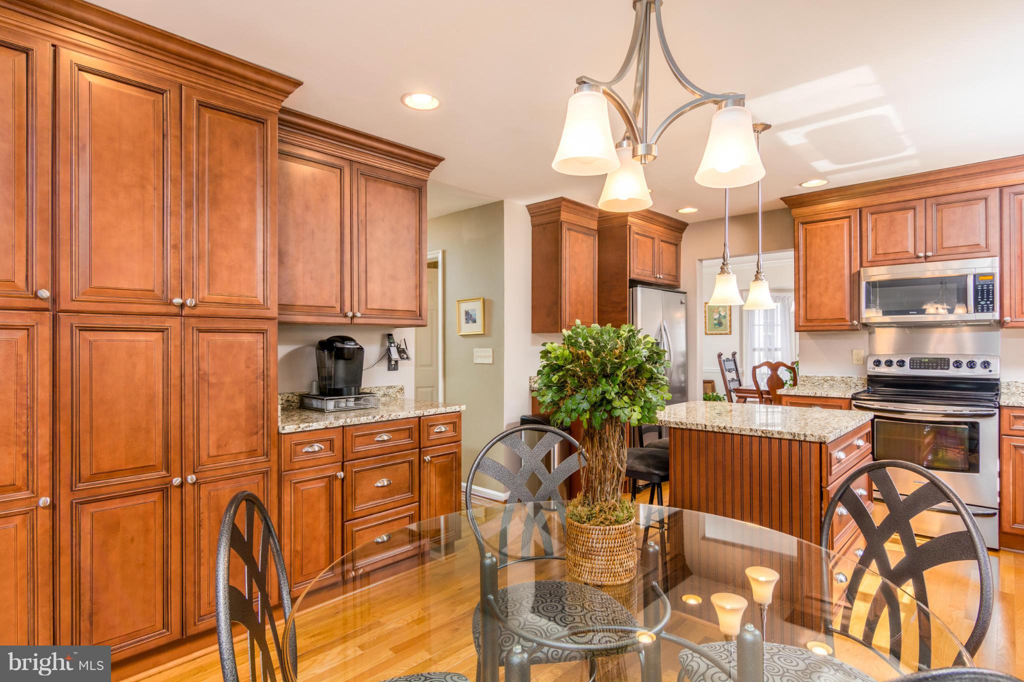 3130 Stonehenge Drive Riva, MD 21140 - Photo 11 of 30 a kitchen with stainless steel appliances a refrigerator a stove a sink dishwasher and white cabinets with wooden floor