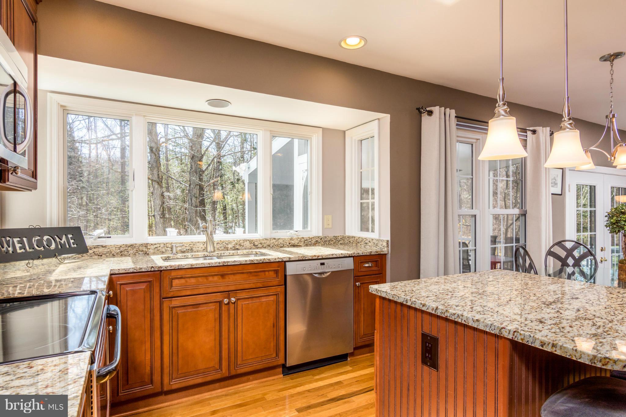 3130 Stonehenge Drive Riva, MD 21140 - Photo 10 of 30 a kitchen with kitchen island granite countertop wooden cabinets and a large window