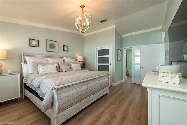 a bedroom with bed and a chandelier