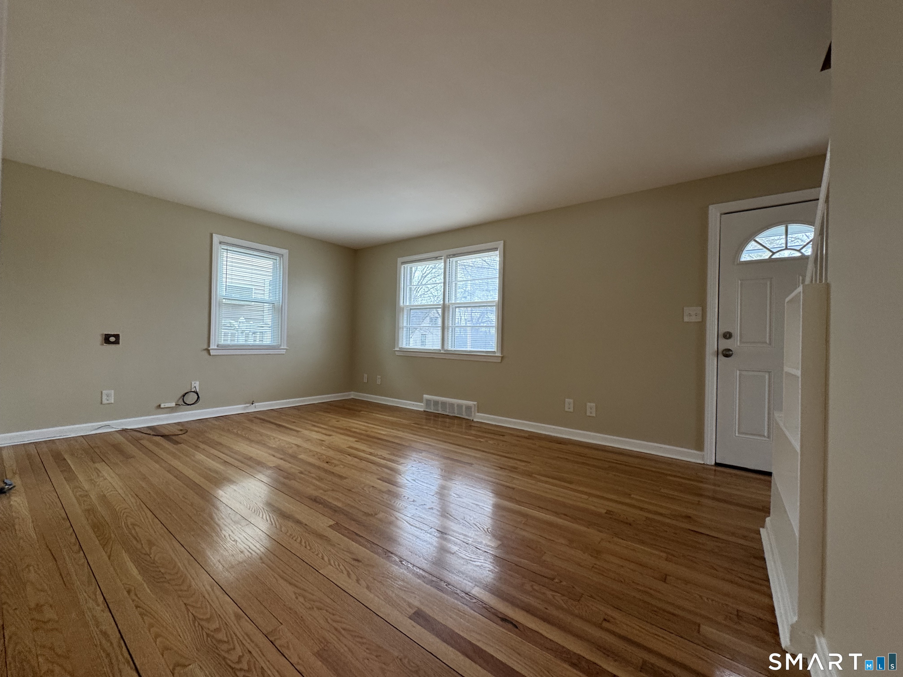 56 Sidney Street Bridgeport, CT 06606 - Photo 3 of 12 an empty room with wooden floor and windows