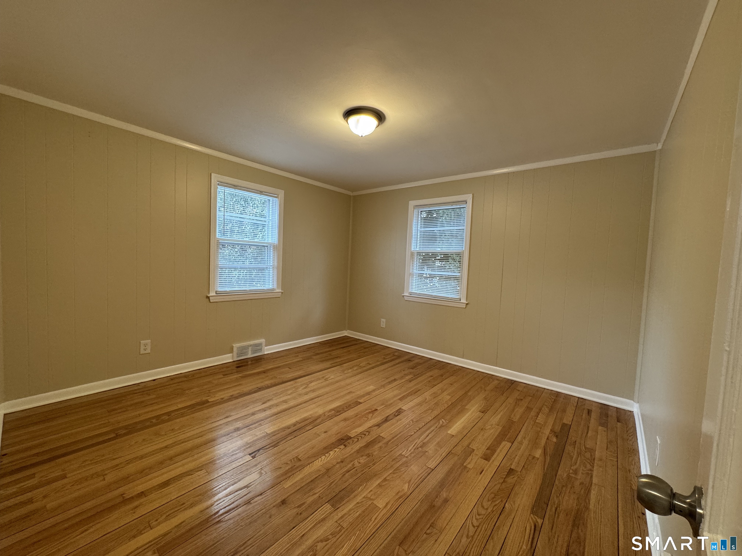 56 Sidney Street Bridgeport, CT 06606 - Photo 5 of 12 a view of an empty room with wooden floor and a window