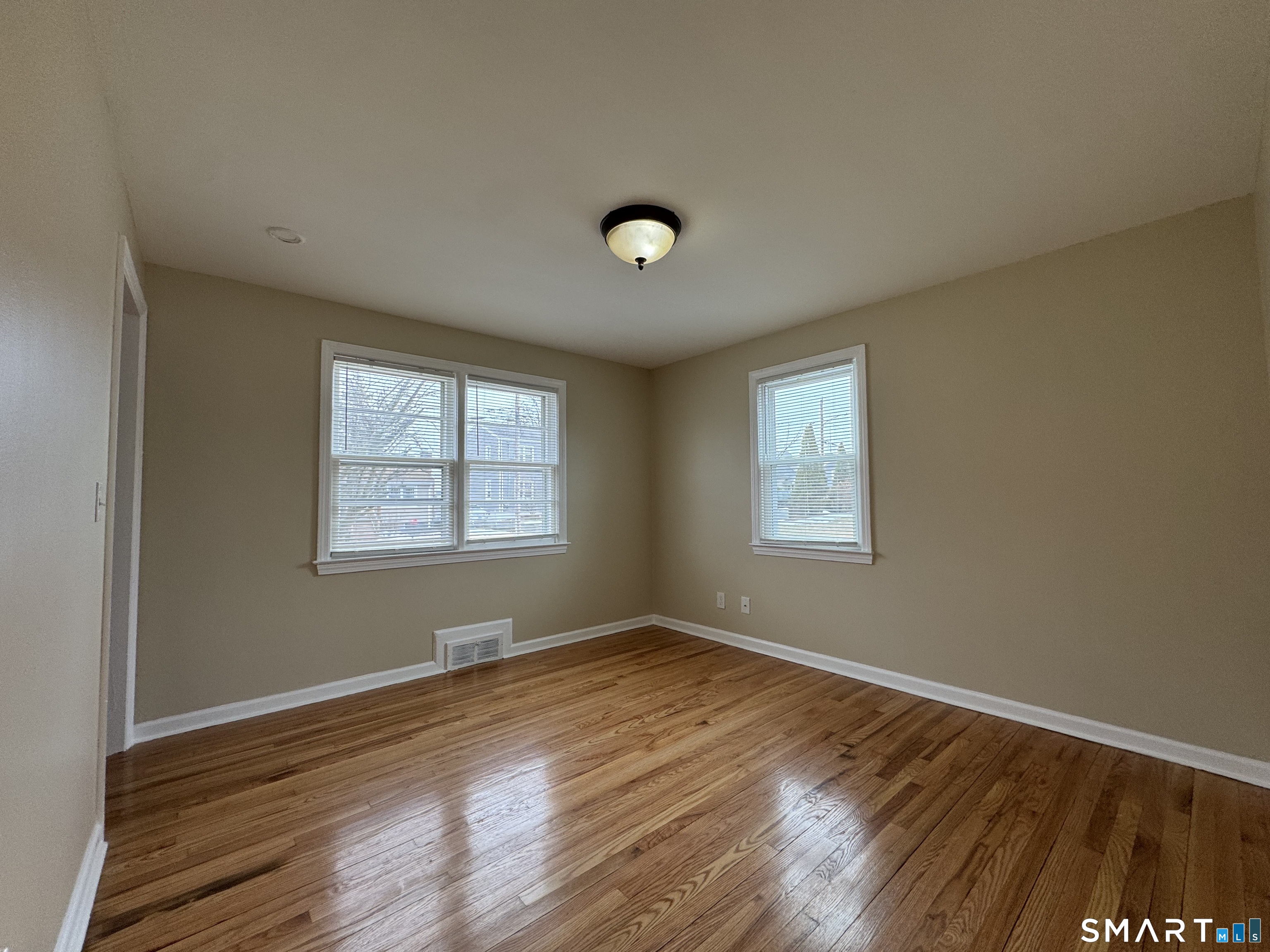 56 Sidney Street Bridgeport, CT 06606 - Photo 6 of 12 a view of an empty room with wooden floor and a window