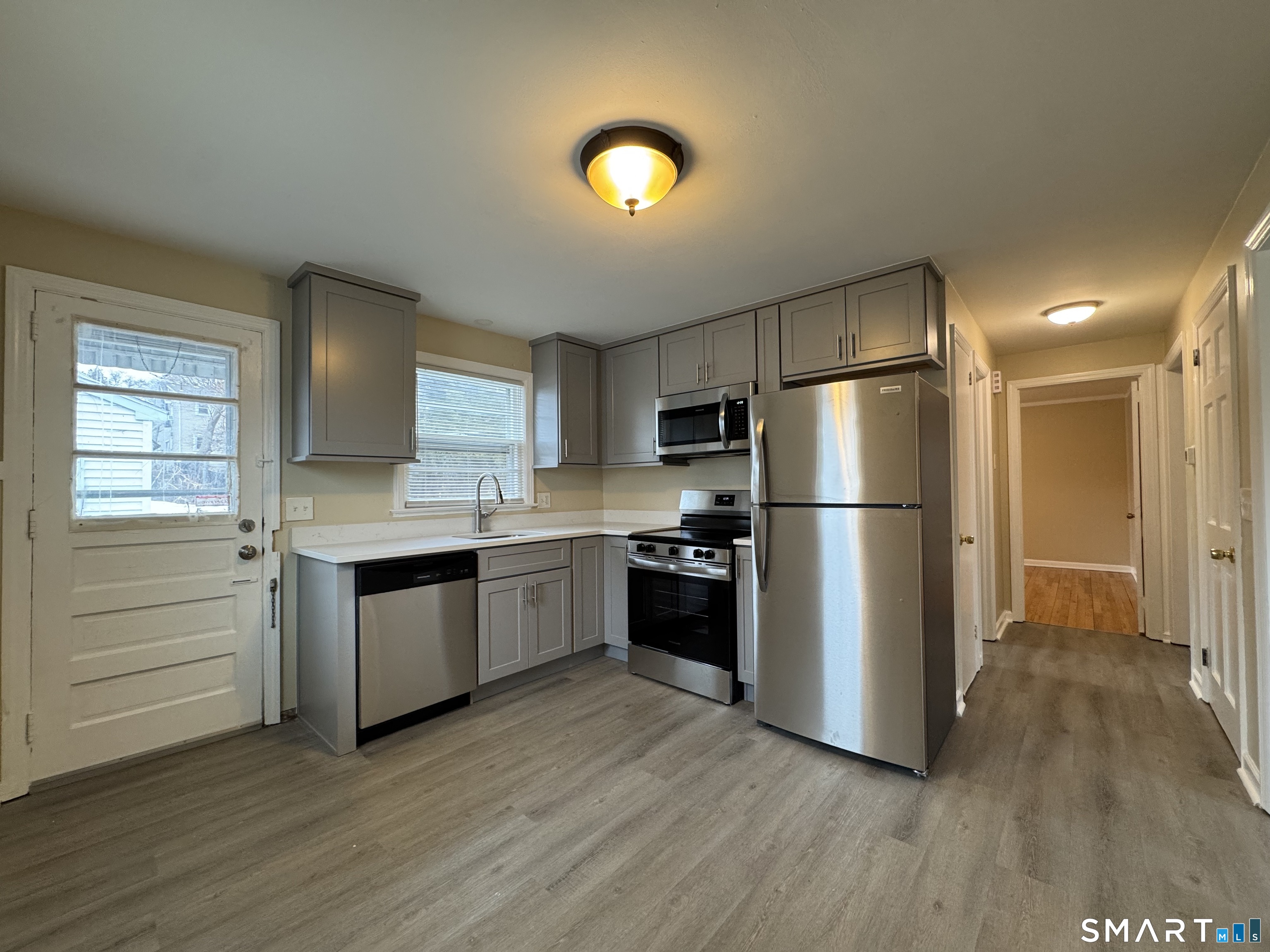56 Sidney Street Bridgeport, CT 06606 - Photo 7 of 12 a kitchen with a refrigerator and a stove top oven