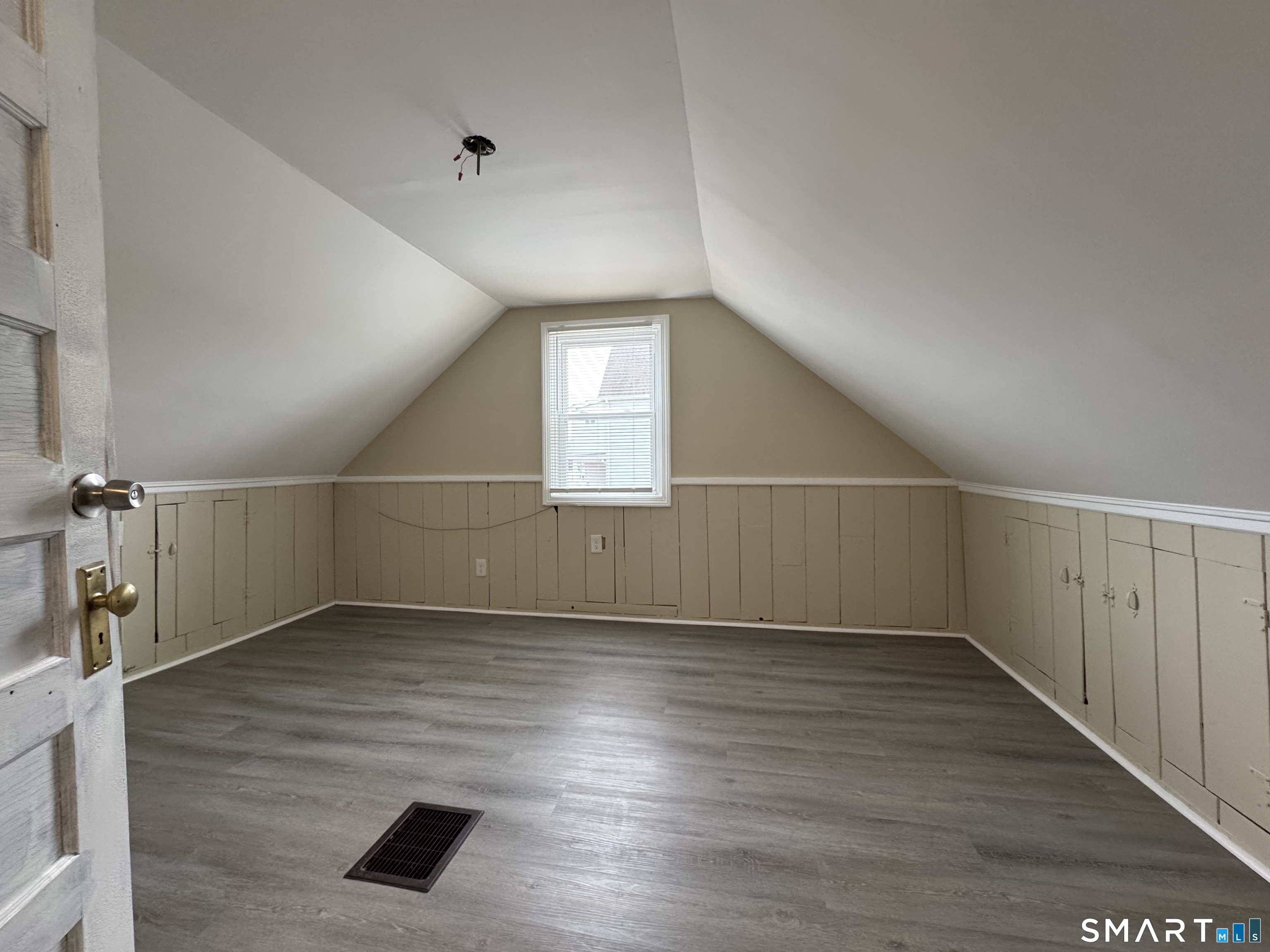 56 Sidney Street Bridgeport, CT 06606 - Photo 10 of 12 an empty room with wooden floor and windows