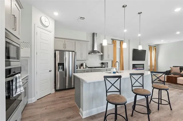 a large kitchen with kitchen island a large counter top space a sink stainless steel appliances and cabinets