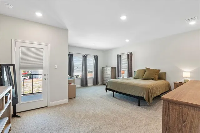 a bedroom with a balcony a bed and a large window