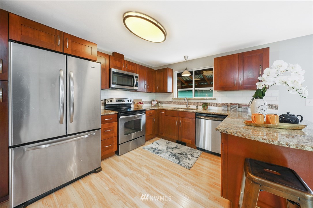820 Southwest 3rd Place Renton, WA 98057 - Photo 4 of 18 a kitchen with granite countertop stainless steel appliances a refrigerator a sink a stove and cabinets