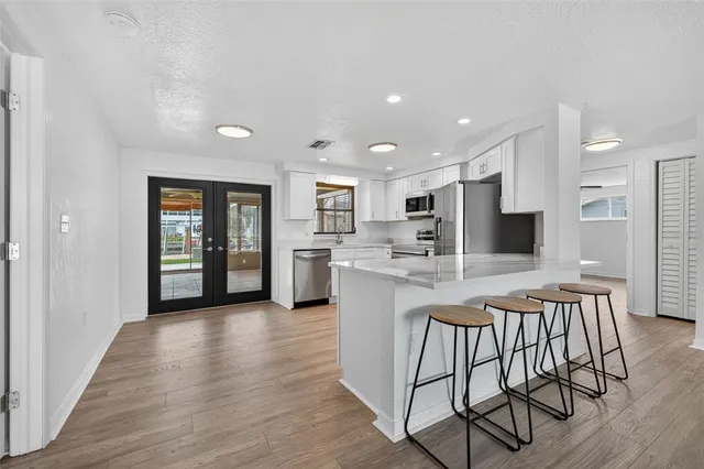 an open kitchen with kitchen island and stainless steel appliances