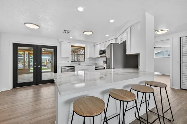 a kitchen with stainless steel appliances a refrigerator sink and microwave