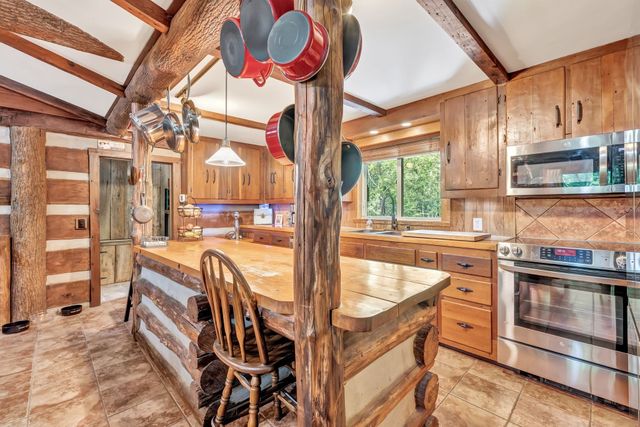 a room with stainless steel appliances lots of white furniture