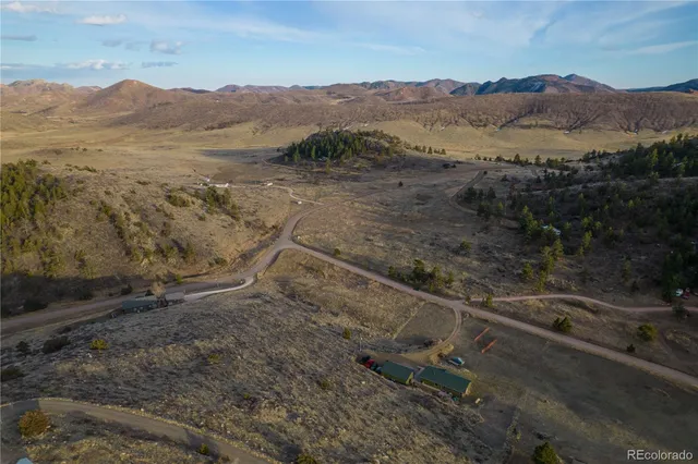 a view of a dry yard with mountains in the background