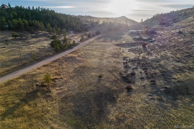 a view of a dry yard with wooden fence