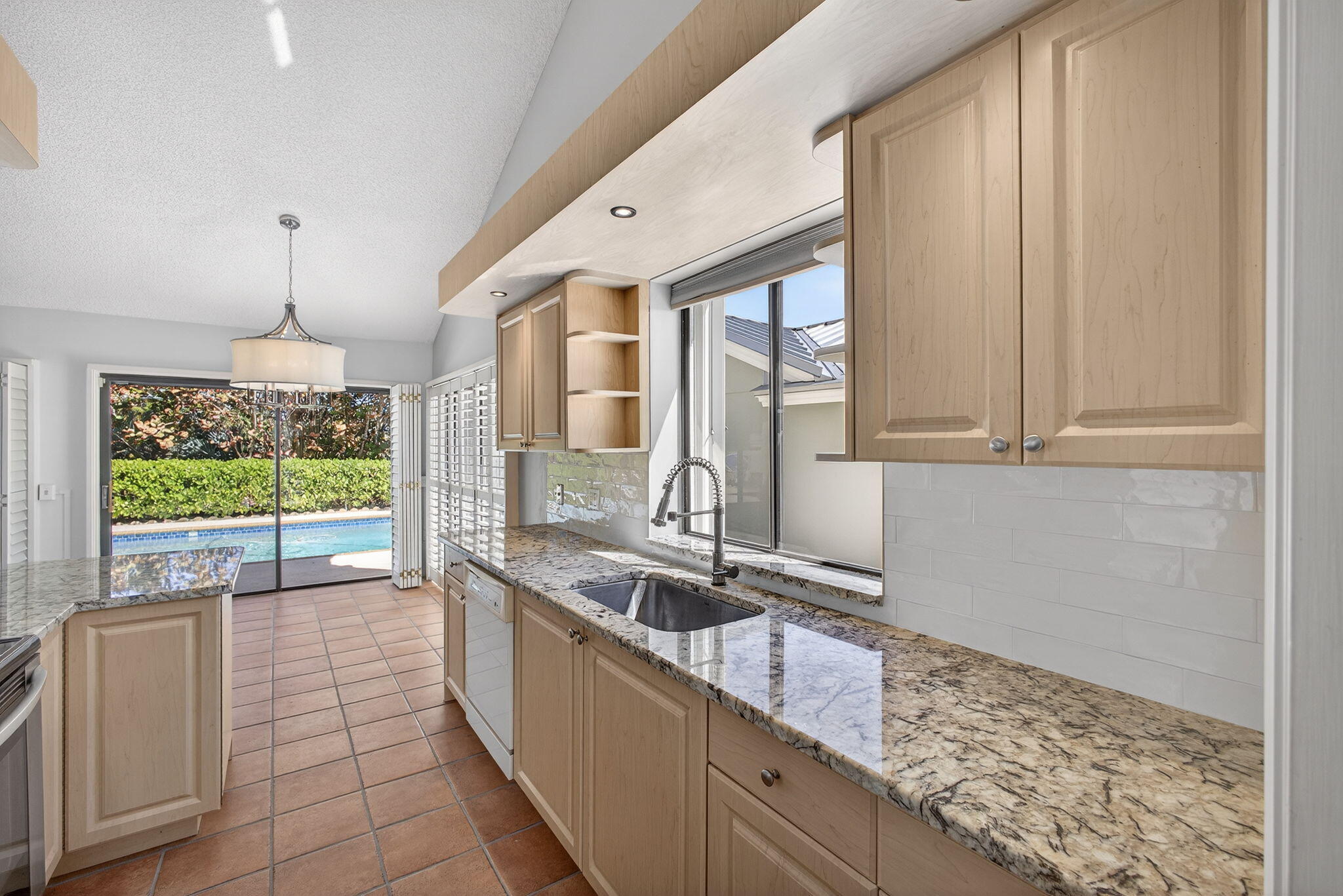 239 Ridge Road Jupiter, FL 33477 - Photo 24 of 75 a large kitchen with kitchen island granite countertop a large window and a white counter top