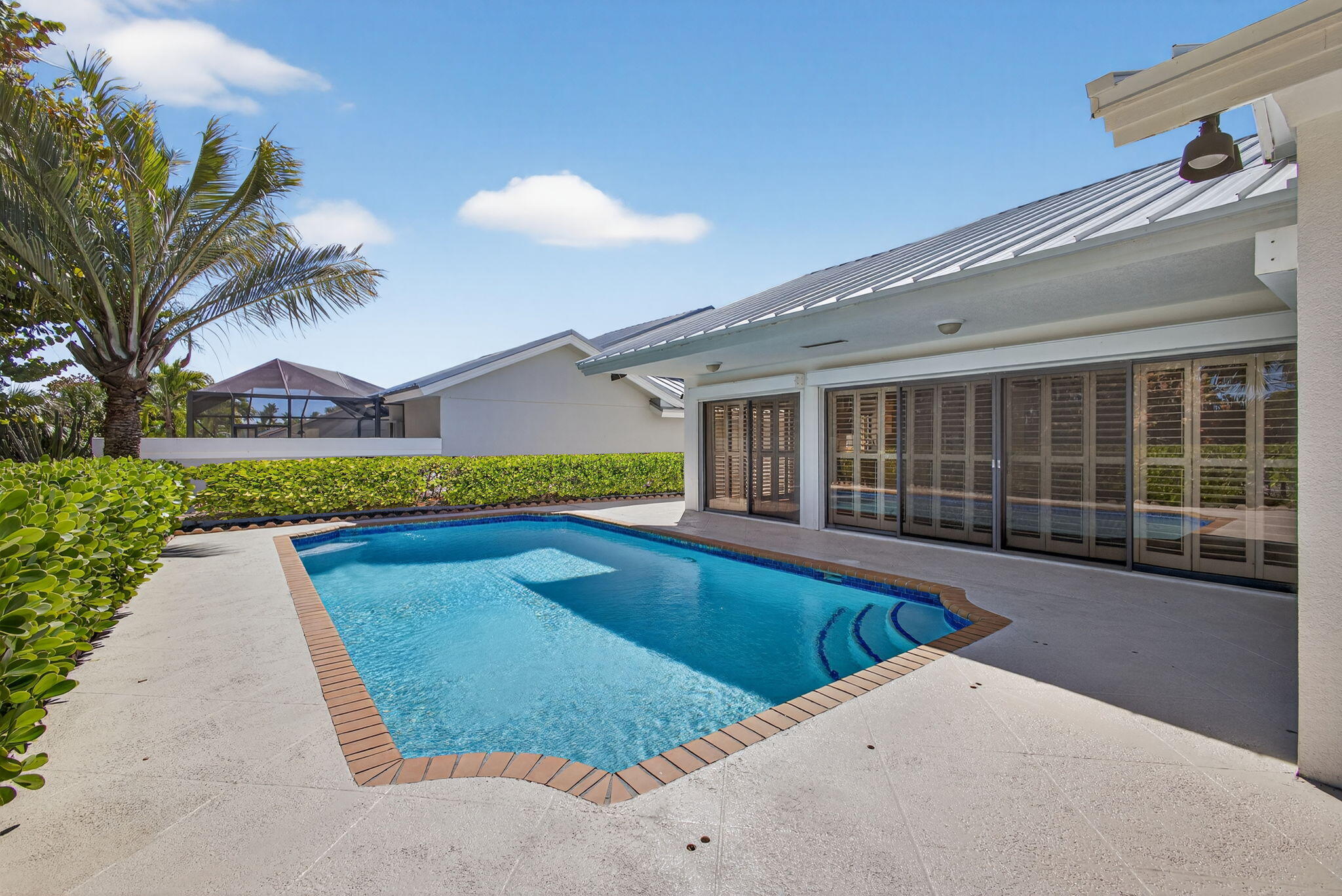 239 Ridge Road Jupiter, FL 33477 - Photo 54 of 75 a view of swimming pool with outdoor seating and house in the background