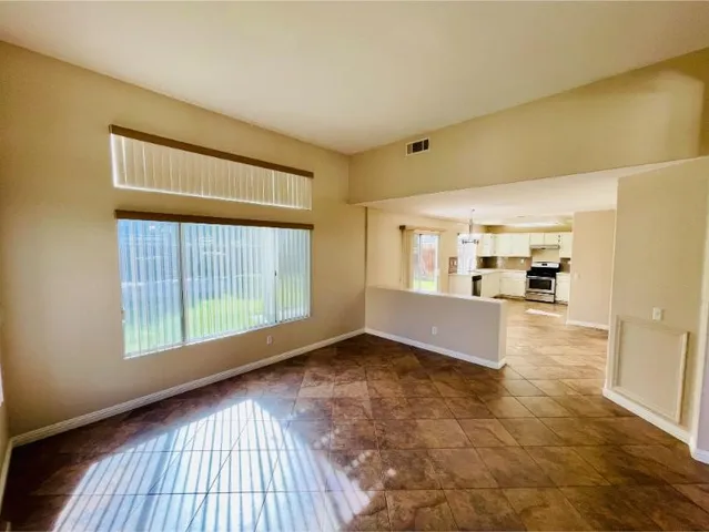 a view of a kitchen with kitchen island a refrigerator a sink dishwasher with a dining table and chairs