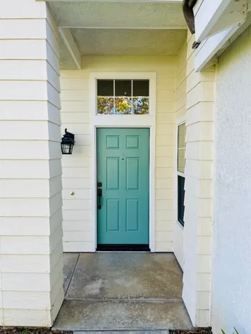 a view of a hallway with entryway and wooden floor
