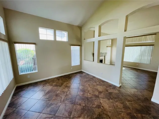 a view of an empty room with window and fireplace