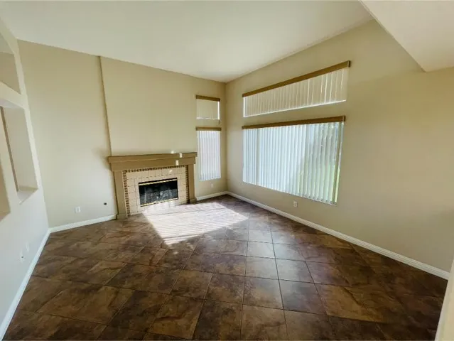 a living room with stainless steel appliances wooden floor and a large window