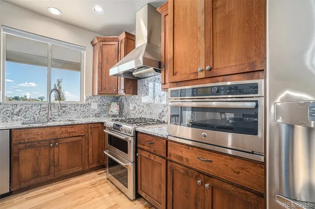 a kitchen with stainless steel appliances granite countertop a stove and a microwave