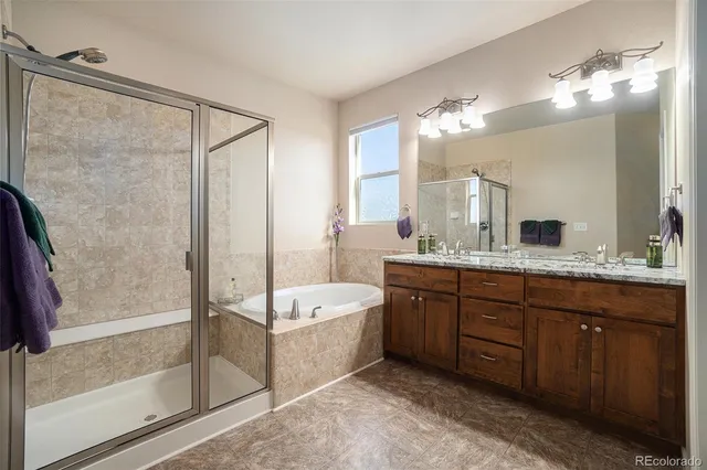 a spacious bathroom with a tub sink shower and mirror