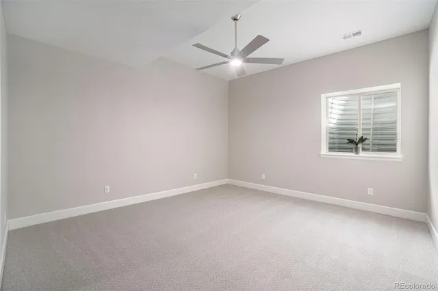 an empty room with a window and a fan