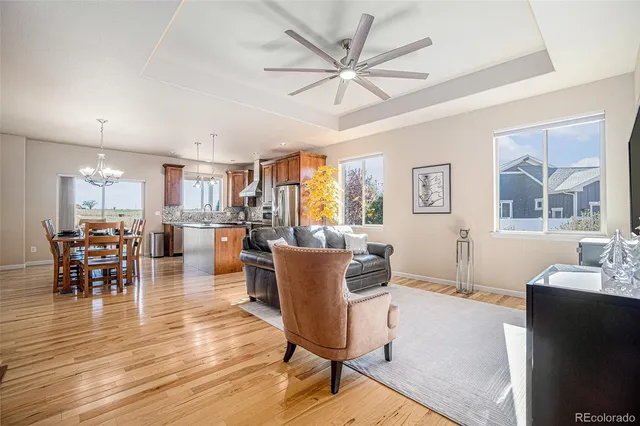 a living room with furniture a dining table and a large window