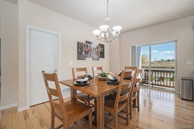a view of a dining room with furniture a chandelier and wooden floor