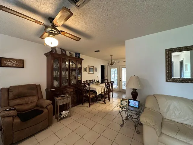 a living room with furniture a dining table and a chandelier