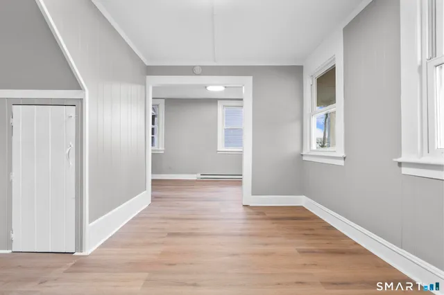 a view of an empty room with wooden floor