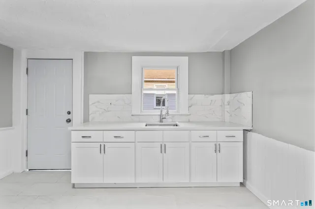 a kitchen with granite countertop white cabinets and stainless steel appliances
