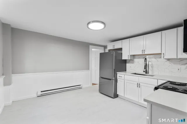 a kitchen with a refrigerator sink stove and cabinets